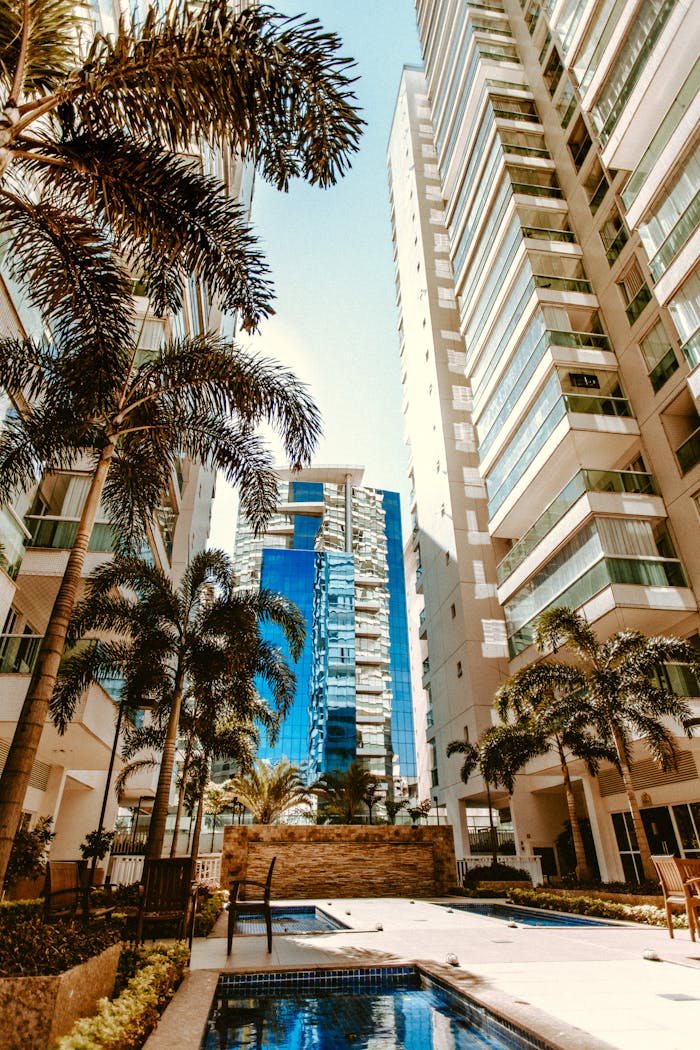 Crafting Captivating Headlines: Your awesome post title goes here A modern cityscape with tall skyscrapers and palm trees surrounding a serene pool.